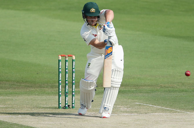 Batsman in white clothing hitting the red ball in a Test match